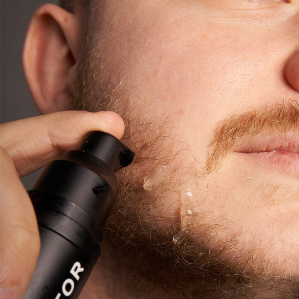 Un homme légèrement barbu applique du sérum activator de MaxBarber sur son visage pour favoriser la croissance de sa barbe.